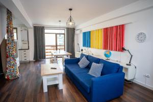 a living room with a blue couch and a table at Barrique 24-4 - Breakfast delivered & Minibar - Free Parking -Officially classified guesthouse in Braşov