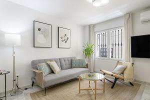 a living room with a couch and a tv at Vicente Espinel Apartment in Ronda
