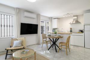 a kitchen and living room with a table and chairs at Vicente Espinel Apartment in Ronda