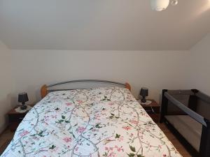 a bedroom with a bed with a floral bedspread at Ubytovanie Málika in Čierny Blh