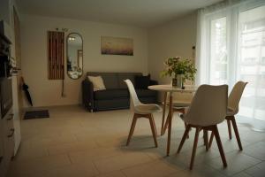 a living room with a table and chairs and a couch at FeWo Reutlingen Ganghoferstr in Reutlingen +2 photos