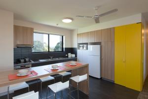 a kitchen with a counter and a yellow door at Western Sydney University Village - Penrith in Penrith