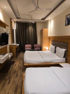 a hotel room with two beds and a television at my divine hotel in Amritsar