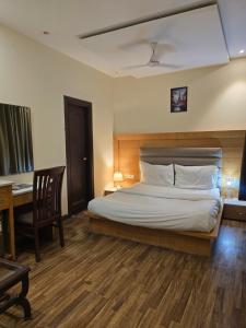 a bedroom with a bed and a desk with a desk at my divine hotel in Amritsar