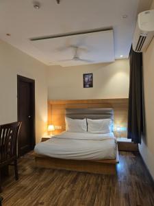 a bedroom with a large bed with a wooden headboard at my divine hotel in Amritsar