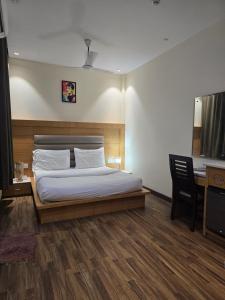 a bedroom with a bed and a desk and a chair at my divine hotel in Amritsar