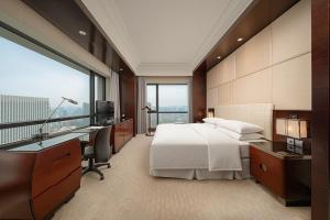 a hotel room with a bed and a desk and a window at Four Points by Sheraton Hangzhou, Binjiang in Hangzhou