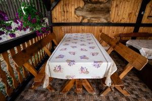 a table and two chairs in a room with a table and flowers at Sapphire Chalet - Moieciu de sus in Moieciu de Sus