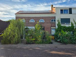 a brick building with solar panels on the roof at Herberg Hanenberg in Wissenkerke