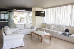 a living room with white couches and a coffee table at Jason Hotel Apartments in Rethymno