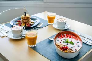 a table with a bowl of cereal and a plate of pancakes at THB Sa Coma Platja in Sa Coma