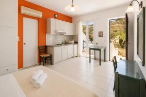 a kitchen with orange walls and a dining room with a table at Villa Zefiros in Kipri