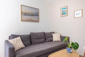 a grey couch in a living room with a table at L'Écume - Cocon breton avec terrasse in Saint-Avé