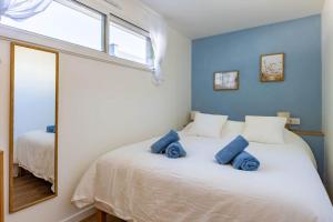 a bedroom with a bed with blue pillows on it at L'Écume - Cocon breton avec terrasse in Saint-Avé