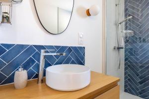 a bathroom with a white sink and a mirror at L'Écume - Cocon breton avec terrasse in Saint-Avé