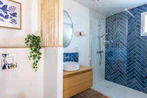 a bathroom with a shower with a sink and a mirror at L'Écume - Cocon breton avec terrasse in Saint-Avé +7 photos