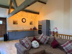 a living room with a couch and a kitchen at Witherslack Hall Farmhouse in Grange Over Sands +40 photos