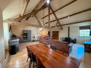 a large living room with a wooden table and chairs at Witherslack Hall Farmhouse in Grange Over Sands