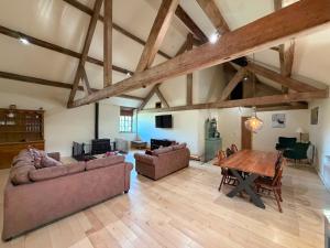 a living room with two couches and a wooden table at Witherslack Hall Farmhouse in Grange Over Sands