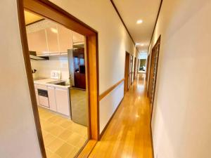 a hallway leading to a kitchen with a doorway at ParkView SAKURA in Aomori
