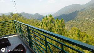 a green balcony with a view of a mountain at Hotel Pine View Villa in Dagshai