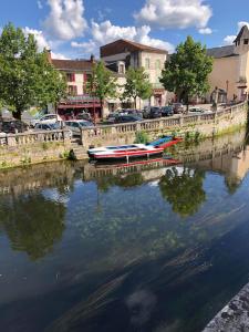 two boats are docked on a river in a city at Gîte 4 personnes in Brantôme +9 photos