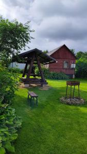 a picnic table and benches in a yard with a building at Vasarnīca Pie Anniņas in Pasteri