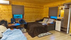 a room with a bed in a log cabin at Vasarnīca Pie Anniņas in Pasteri