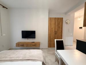 a bedroom with a bed and a tv on a wall at Coastal Pine Appartment in Golem