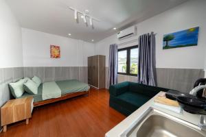 a living room with a green couch and a sink at Danna House Da Nang BNB in Danang