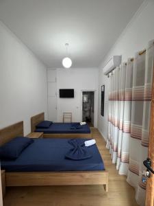 a bedroom with two beds and a tv at Central Rooms Permet in Përmet +19 photos