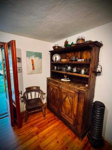 a room with a large wooden cabinet with a clock on it at Le Sapin 2 in Cogne