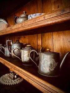 a group of tea pots on a wooden shelf at Le Sapin 2 in Cogne