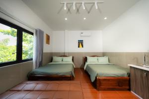 two beds sitting in a room with a window at Danna House Da Nang BNB in Danang