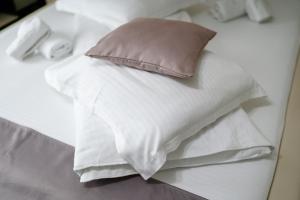 a pile of white sheets and a pillow on a bed at Sapphire Chalet - Moieciu de sus in Moieciu de Sus