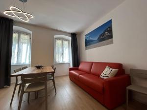a living room with a red couch and a table at Rivacentro 4 in Riva del Garda