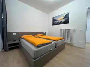 a bedroom with a bed with orange pillows on it at Rivacentro 4 in Riva del Garda