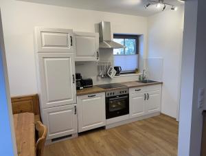 a kitchen with white cabinets and a stove top oven at Ruhig wohnen in Hüttblek in Hüttblek