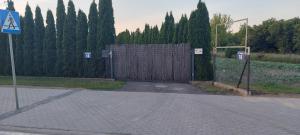 a gate on a road with trees and a fence at Hello Tu Modlin in Zakroczym