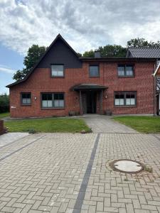 a brick house with a driveway in front of it at Ruhig wohnen in Hüttblek in Hüttblek