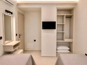 a bedroom with two beds and a tv on a wall at Amara 2 bedrooms apartment - Alykanas in Alikanas