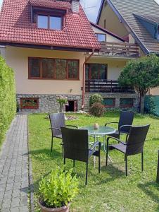 a patio with chairs and a table in front of a house at Penzion Helena in Stará Lesná