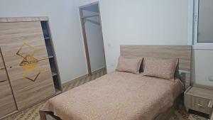 a small bedroom with a bed and a mirror at La Casa de Madrid in Larache