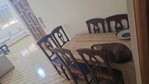 a dining room table and chairs with a cat sleeping on it at La Casa de Madrid in Larache