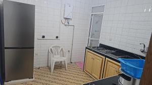 a kitchen with a refrigerator and a chair in it at La Casa de Madrid in Larache