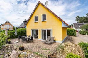 a yellow house with a table and chairs at Haus 29 in Röbel