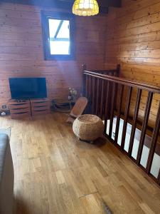 a living room with a television and a chair at Chalet N5 avec vue in Les Angles