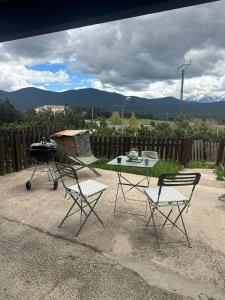 a barbecue and two chairs and a table and a grill at Chalet N5 avec vue in Les Angles