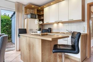 a kitchen with a wooden counter and black leather chairs at Haus 29 in Röbel