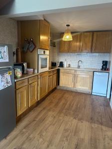 a kitchen with wooden cabinets and a refrigerator at Chalet N5 avec vue in Les Angles